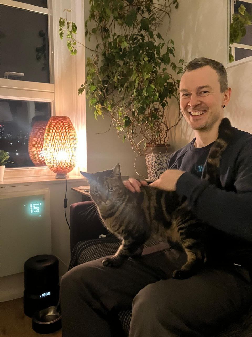 Eugene Zubanov with Reggie the cat, both looking happy